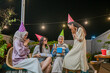 © Odua Images - A joyful group of close friends celebrating and bonding together under sparkling, twinkling lights