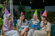 © Odua Images - A group of friends at a festive gathering full of party hats and joyful laughter