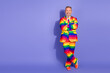 © deagreez - Elderly man in a vibrant rainbow suit exuding confidence and style against a purple background.