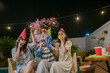 © Odua Images - Friends joyfully celebrate together, wearing colorful hats and holding sparklers on a fun night