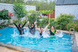© Odua Images - A vibrant and lively group of women enjoying a refreshing splash in a private pool oasis