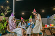 © Odua Images - A fun night with friends in colorful hats, sharing laughter and joyful experiences together