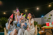 © Odua Images - Friends gather for a vibrant outdoor party filled with festive accessories and joyful moments