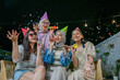 © Odua Images - A lively gathering of friends in party hats blowing bubbles and celebrating together.