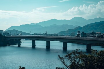 Wall Mural - Scenic bridge spanning a river against mountain backdrop at twilight