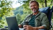© Pinklife - A middle-aged man in casual attire sits in a lawn chair holding a coffee cup, working on a laptop in a serene outdoor setting, exuding happiness and calm.