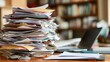 © addymawy - A large stack of papers sits on a wooden desk