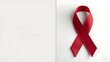 © Haani Pasha - Image of a red ribbon to create awareness for HIV AIDS and its prevention with copy space of the left