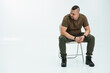 © Galka3250 - Thoughtful man sitting on a chair in a minimalist studio