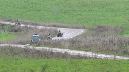 Wall Mural - a convoy of British army ATV quad bike four wheeled all terrain bikes driving along a dirt track 