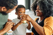 © Lumos sp - child family kitchen boy son mother father drink breakfast milk healthy drinking food eating glass home black african american father man together love cute childhood