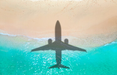 Airplane shadow flying over beautiful exotic tropical beach with sunny cay - Summer vacation travel concept . A happy family on summer holidays . Travel traveling vacation sea symbolic picture
