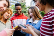 © Xavier Lorenzo - Multiracial young people watching funny content on mobile phone app. Millennial diverse friends having fun using smart mobile phone devices outdoors. Youth and technology concept