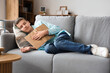 © Pixel-Shot - Teenage boy sleeping with book on sofa in living room
