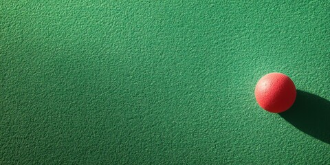 Poster - A red ball resting on a green textured surface, creating a minimalistic visual effect.