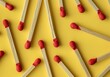 © SHOTPRIME STUDIO - matches, yellow background, minimalistic design, pattern, red tips, flat lay composition, bright colors, contrast, simple arrangement, everyday objects, creative layout, modern aesthetic