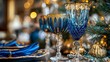 © Ben Kuang - Elegant blue glassware decorates a festive holiday table setting with sparkling lights.