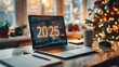 © visoot - Front view of a laptop screen, Large letters '2025' on the screen. In the background is a cozy festive office with a Christmas tree and a large window. Festive atmosphere.