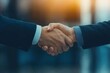 © Zenith - A close-up image of two people shaking hands, symbolizing agreement, collaboration, or a business deal in a professional setting.