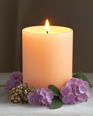 Wall Mural - A softly glowing candle surrounded by delicate purple flowers, creating a serene and calming atmosphere.