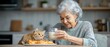 © AnuStudio - Wellness health and Natural remedies Concept, An elderly woman enjoys a meal with a curious cat, sharing a moment of joy and companionship in a cozy kitchen setting.