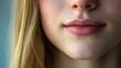 © VirtualVista - Close-up of a young woman's lips with a soft pink hue, framed by long blonde hair, showcasing smooth skin and natural beauty.