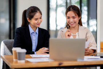 Wall Mural - Two asian business women Accounting using calculating income-expenditure and analyzing real estate investment documents data report Financial and tax systems concept.