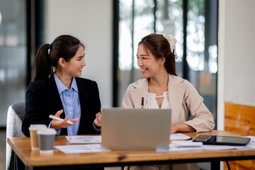 Wall Mural - Two asian business women Accounting using calculating income-expenditure and analyzing real estate investment documents data report Financial and tax systems concept.