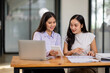 © David - Financial Business two women analyze the graph of the company's performance to create profits and growth, Market research reports and income statistics, Financial and Accounting concept.