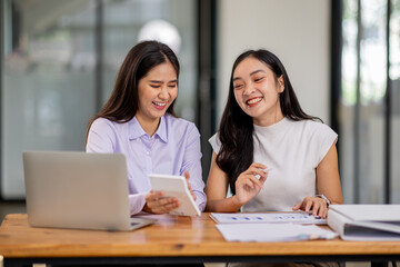 Wall Mural - Financial Business two women analyze the graph of the company's performance to create profits and growth, Market research reports and income statistics, Financial and Accounting concept.	