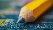 © Kultivad - Close-up of a sharpened yellow pencil resting on a textured surface with colorful splashes, symbolizing creativity and motivation in education and coaching.