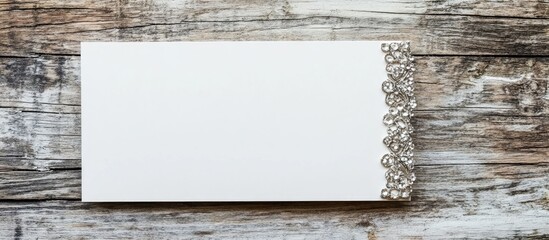 Poster - Elegant blank white business card mockup featuring silver embellishments on a rustic vintage wooden surface for professional branding display.