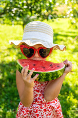 Poster - Child eating watermelon in the garden. Selective focus.