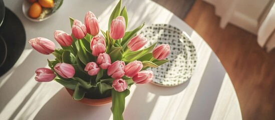 Poster - Elegant arrangement of pink tulips in a pot displayed on a table with soft natural light creating a warm kitchen ambiance.