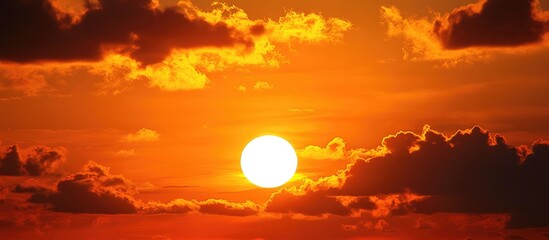 Poster - Sunset peeking through clouds creating a warm and tranquil atmosphere with subtle hues of orange and yellow in the evening sky.