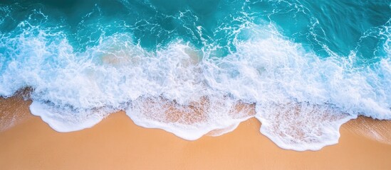 Poster - Aerial view of vibrant ocean waves meeting a tranquil sandy beach texture capturing serene coastal beauty and natural patterns