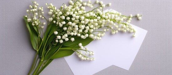 Wall Mural - Lily of the valley bouquet on blank paper background overhead view ideal for text placement and floral arrangements in flat lay photography