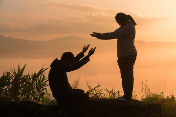 Wall Mural - Serene embrace of nature, Christian man and woman worship Jesus Christ with hands raised in prayer, silhouetted against sunrise. worship, christian, morning, man, woman, jesus christ, sunrise.