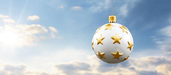 Poster - Golden ornament with stars hanging against a bright sky enhancing the festive spirit of Christmas celebrations outdoors.