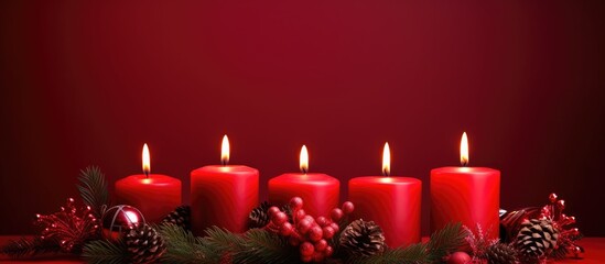 Poster - Warm winter scene with red candles and fir branches on a red backdrop creating a cozy atmosphere ideal for festive celebrations and decorations