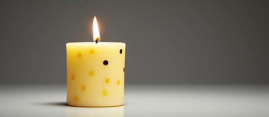 Poster - Yellow dotted candle glowing softly on a minimalistic background creating a serene and calming atmosphere for relaxation and decor