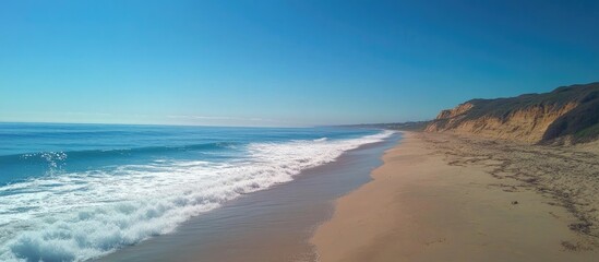Poster - Tranquil beach scenery with clear blue skies gentle ocean waves and sandy shoreline capturing the essence of summer relaxation and beauty