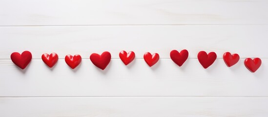 Aufkleber - Line of red heart decorations on a rustic white wooden background creating a romantic and festive atmosphere for love related themes