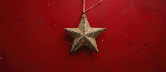 Poster - Christmas star decoration on textured red background captured from above festive holiday theme