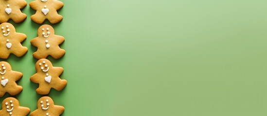 Poster - Gingerbread cookies lined up on a vibrant green background perfect for festive holiday themes and creative culinary designs