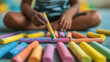 © Sarawut - Colorful chalk pieces scattered on floor as child draws creatively. vibrant colors and playful atmosphere evoke joy and imagination