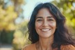 © Anjali - Happy  confident middle aged Hispanic woman outdoors on sunny day.
