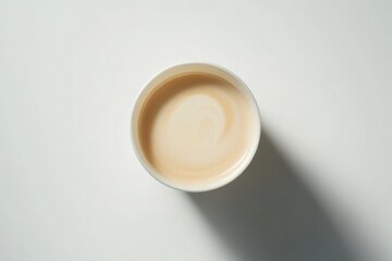 Poster - A top view of a cup filled with light-colored liquid on a plain background.