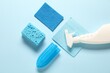 © New Africa - Spray bottle of cleaning product and tools on light blue background, flat lay