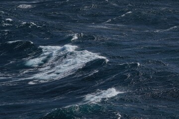 Wall Mural - dark ocean waves with white foam creating dynamic seascape. turbulent water reflects sense of power 